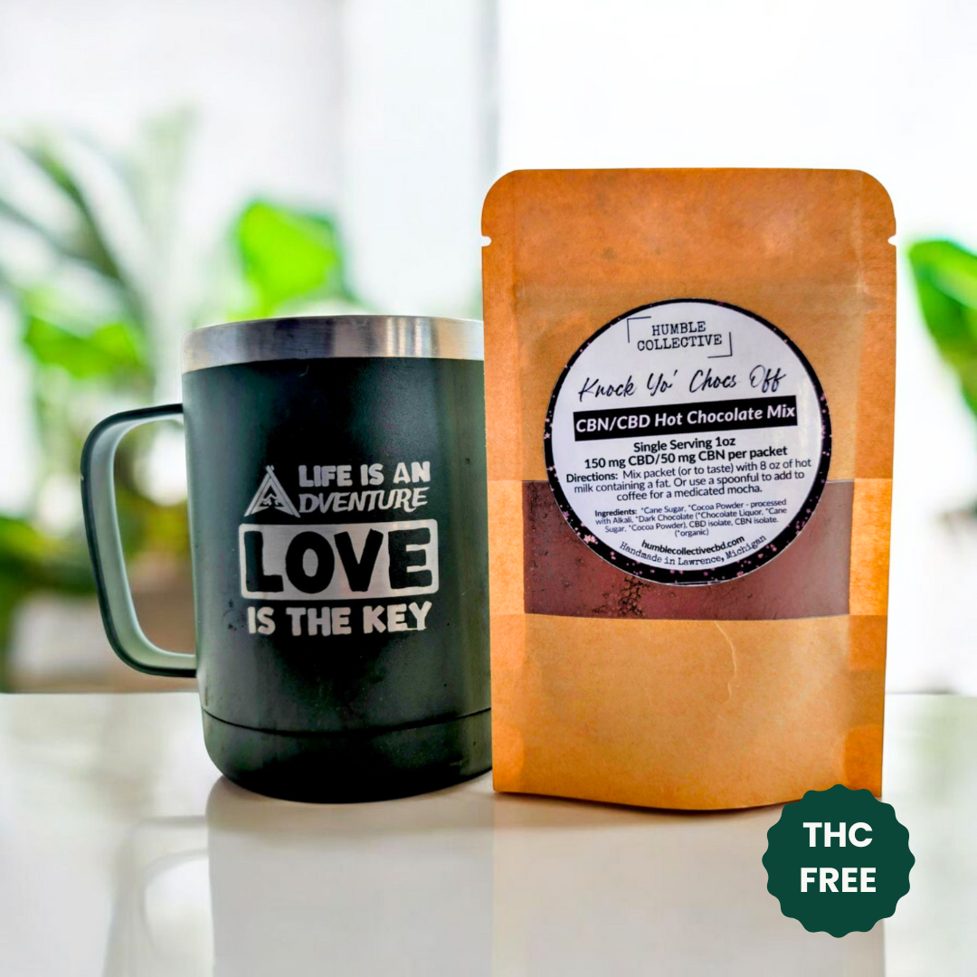 Humble Collective CBN/CBD hot chocolate mix pouch beside a mug on a kitchen counter.