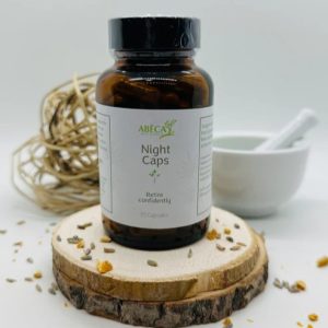 ABĒCA Naturals Night Caps herbal capsule bottle on a wooden slice.