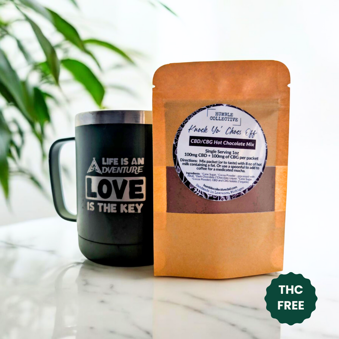 Humble Collective CBG/CBD hot chocolate mix pouch beside a mug on a kitchen counter.