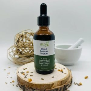 Abeca Naturals Blood Pressure Tincture 2 oz bottle, an herbal blend with lemon balm and yarrow, displayed on a wooden slice with natural decor in the background